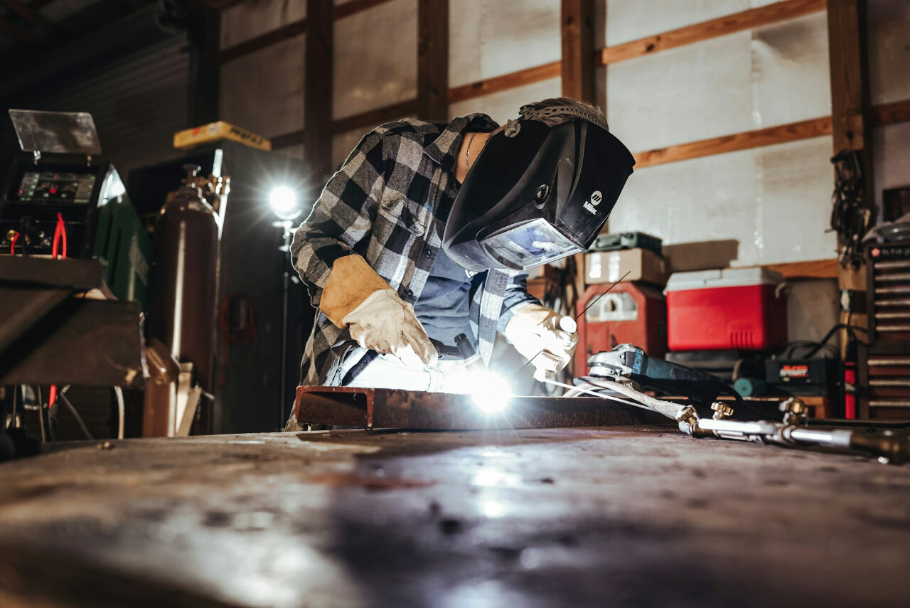 a welder using spot welding versus stud welding to weld a metal component